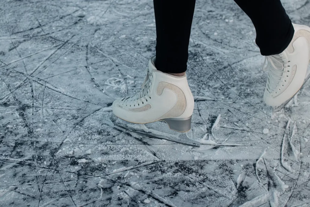 Frau beim Eislaufen mit weißen Schlittschuhen