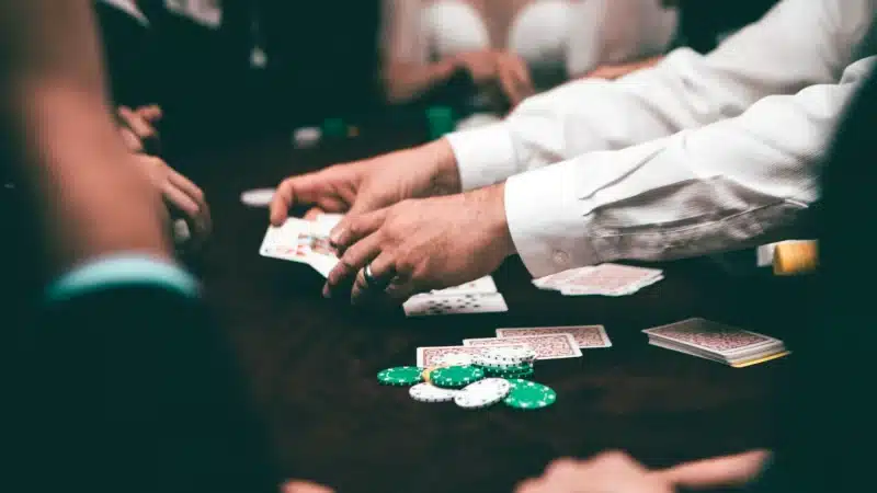 Dealer deckt die Karten der Spieler beim Poker auf