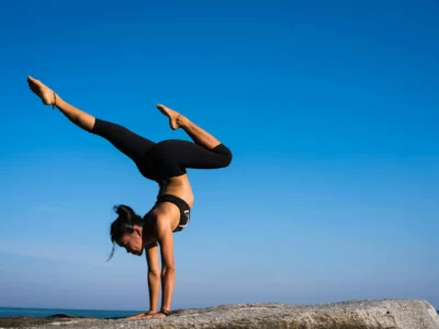 Frau praktiziert Yoga am Meer