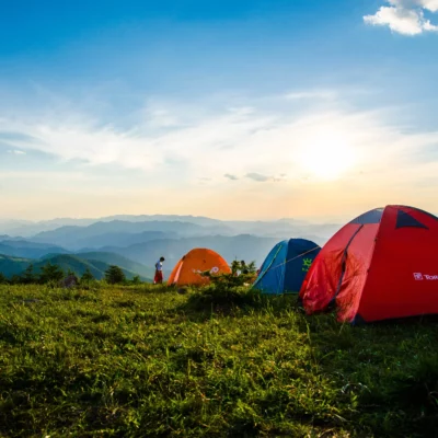 Mehrere Menschen campen auf einem Berg mit Zelten