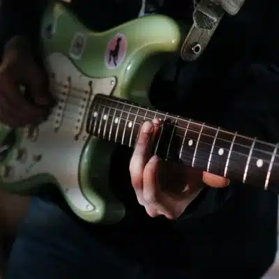 grüne E-Gitarre wird gespielt von nah