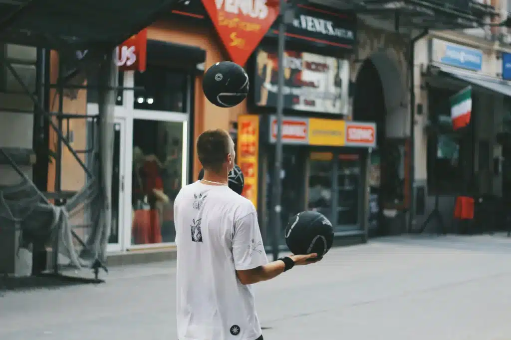 Mann Jongliert mit Basketbällen auf der Straße