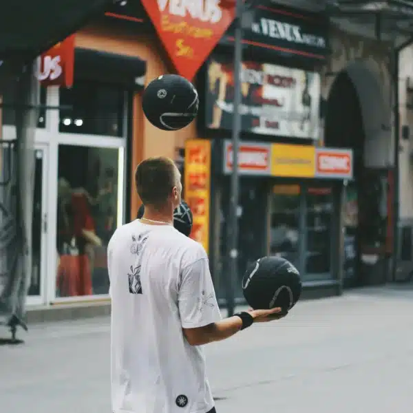 Mann Jongliert mit Basketbällen auf der Straße